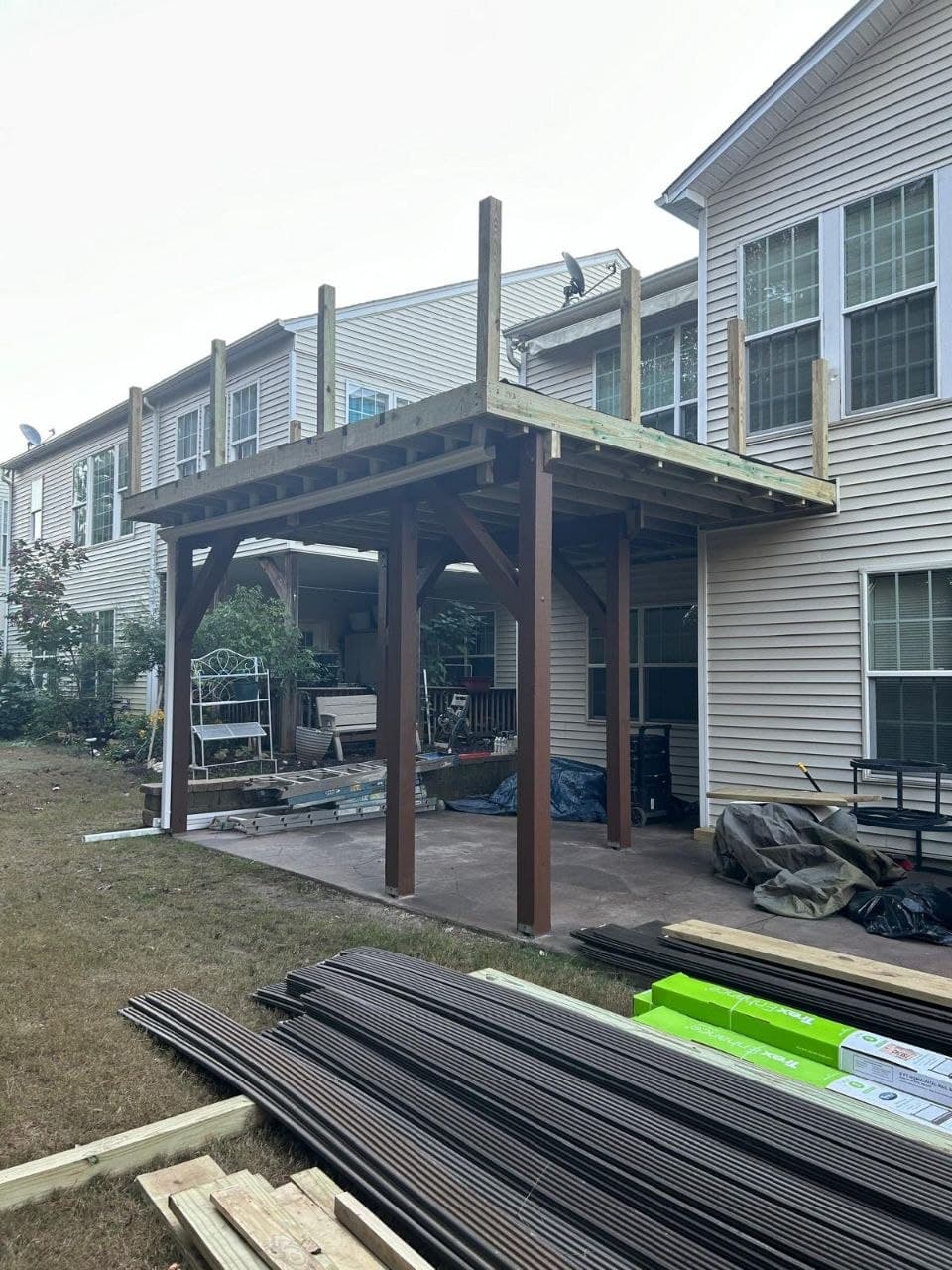 Covered patio with second-story deck being built