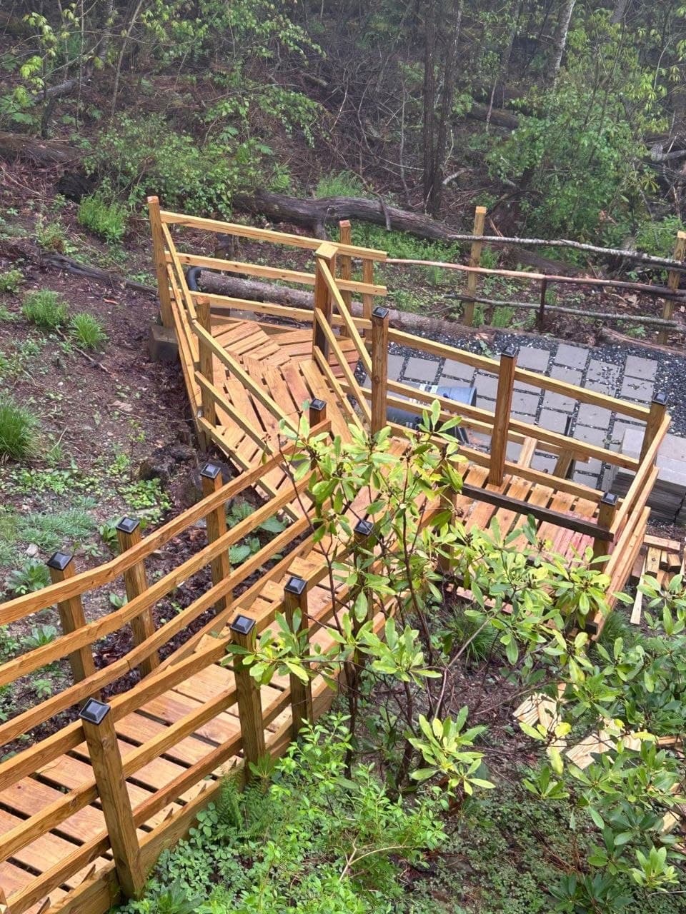 Multi-level wooden walkway and stairs built down a wooded hillside