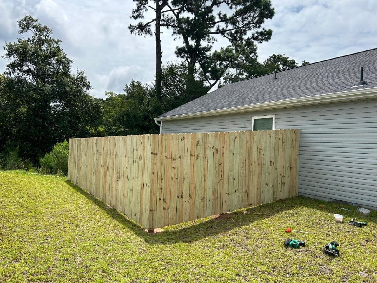 Finished wooden privacy fence alongside a home