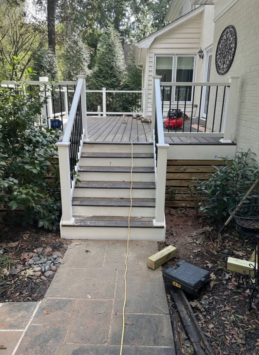 New composite deck with white railings and stairs during construction